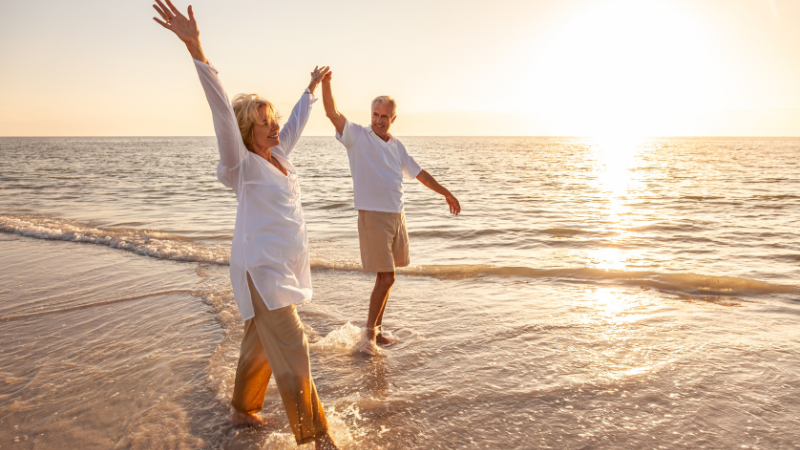 two retirees walking along the beach